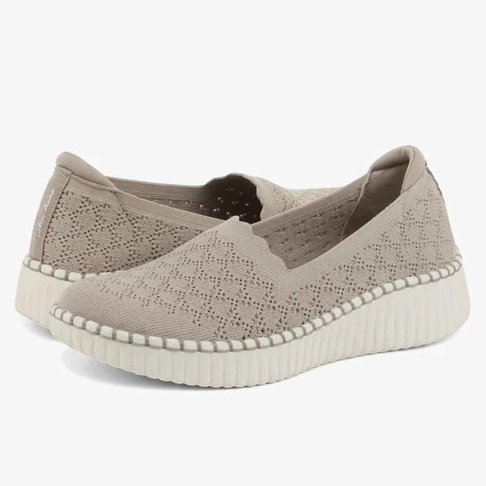 Taupe Skechers Women's Wilshire Blvd knitted slip-on shoes with white ridged wedge soles, shown from a low angle.