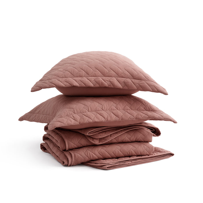 GentleSoft basket-weave quilt set in muted rose, folded with pillow shams. Product shot for e-commerce.