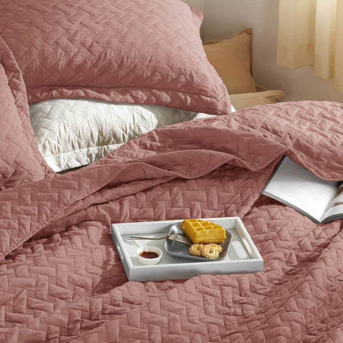 GentleSoft rose basket-weave quilt set with shams on bed, featuring breakfast tray and book. Textured polyester.