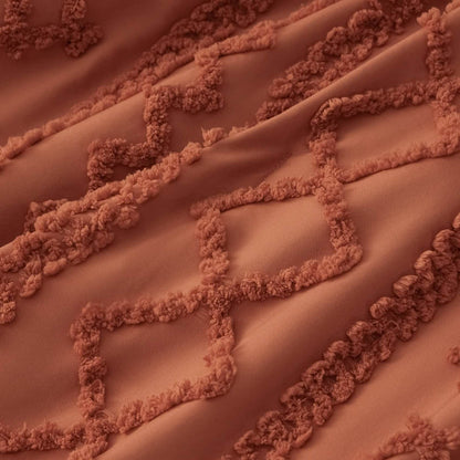 Close-up of GentleSoft burnt orange comforter showing raised diamond embroidery pattern and soft microfiber texture.