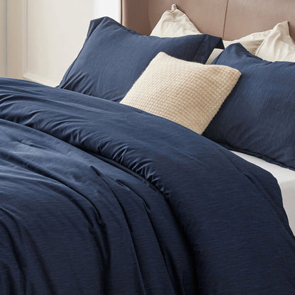 Navy blue GentleSoft comforter set with dual-tone texture on a bed with accent pillow.