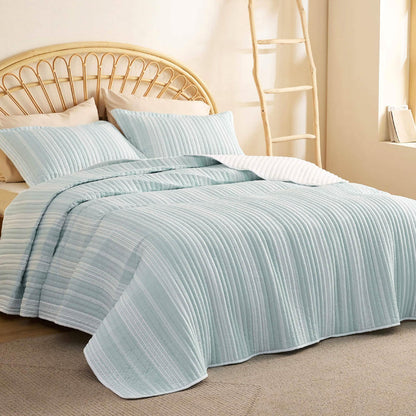 GentleSoft Chill Vibes Quilt Set, light blue and white striped, textured, on a bed with wicker headboard.