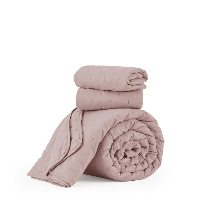 GentleSoft Clover Quilt Set in rose, folded and partially unrolled showing clover embossed pattern and ultrasonic binding.