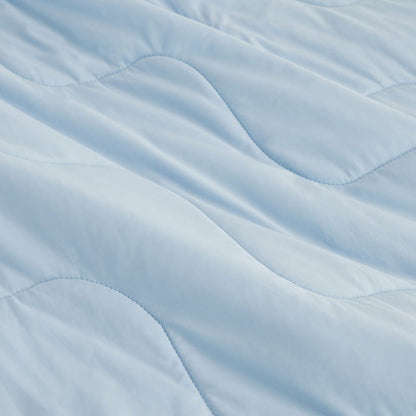 Light blue GentleSoft cooling blanket close-up showing silky nylon texture and wavy stitching.