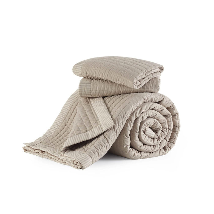 GentleSoft Corduroy Pattern Quilt Set in beige, showing channel stitching texture and striped border, folded and rolled.