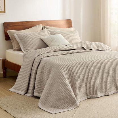 Beige GentleSoft corduroy quilt set on wooden bed, featuring plush microfiber and channel stitching texture.
