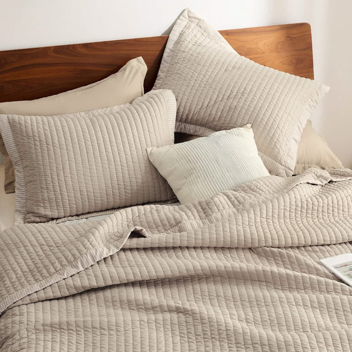 GentleSoft Corduroy Quilt Set in beige showcasing channel stitching texture on a wooden bed with pillows.