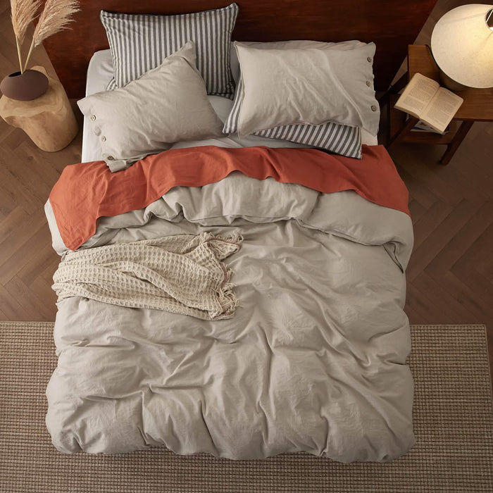 GentleSoft light beige cotton linen duvet set on bed with throws and striped/button pillowcases.