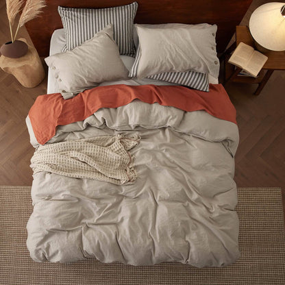 GentleSoft light beige cotton linen duvet set on bed with throws and striped/button pillowcases.