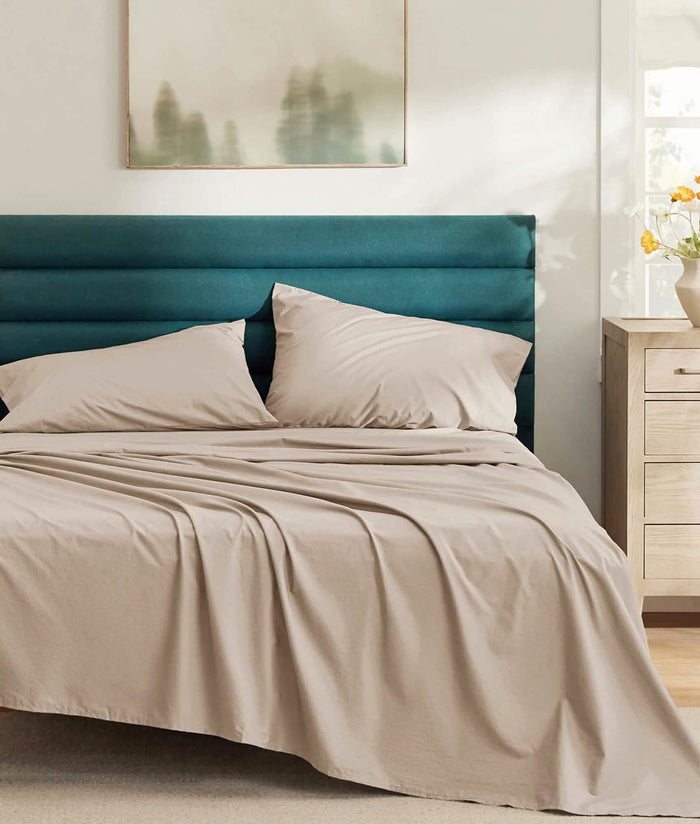 Taupe GentleSoft Cotton Percale sheet set on bed, soft & breathable texture in sunlit bedroom.