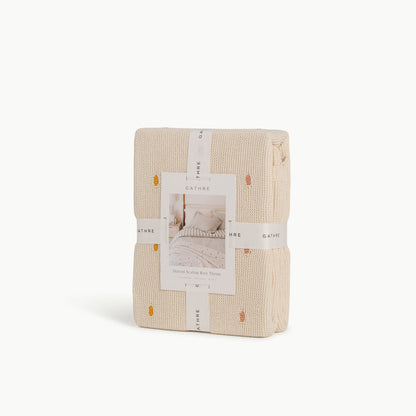 Ivory@Cotton knit throw blanket with dotted texture and scalloped edge in packaging