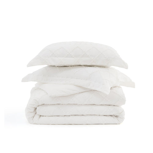 White boho duvet cover and pillow shams with diamond tufted embroidery stacked.