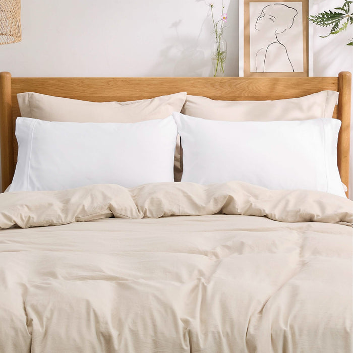 Two white GentleSoft microfiber pillowcases on a neatly made bed with neutral bedding and wooden headboard. Product page.