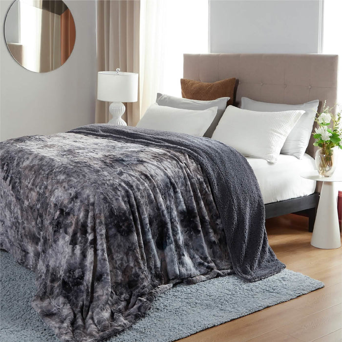Charcoal grey marbled GentleSoft Faux Fur Sherpa blanket draped on bed, showcasing plush fur and Sherpa sides for cozy decor.