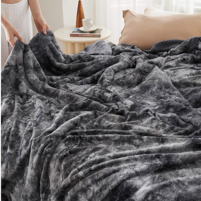 Dark grey marbled GentleSoft Faux Fur Sherpa blanket on bed, showcasing plush texture and cozy Sherpa side.