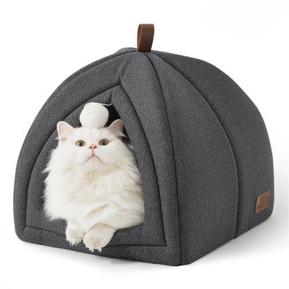 Dark gray faux-linen cat tent with a fluffy white cat peeking out, featuring a dangling pom-pom toy and faux-leather handle.