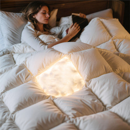 Woman enjoying comfort under a fluffy PureWoven™ feather down comforter with visible soft, premium fill.