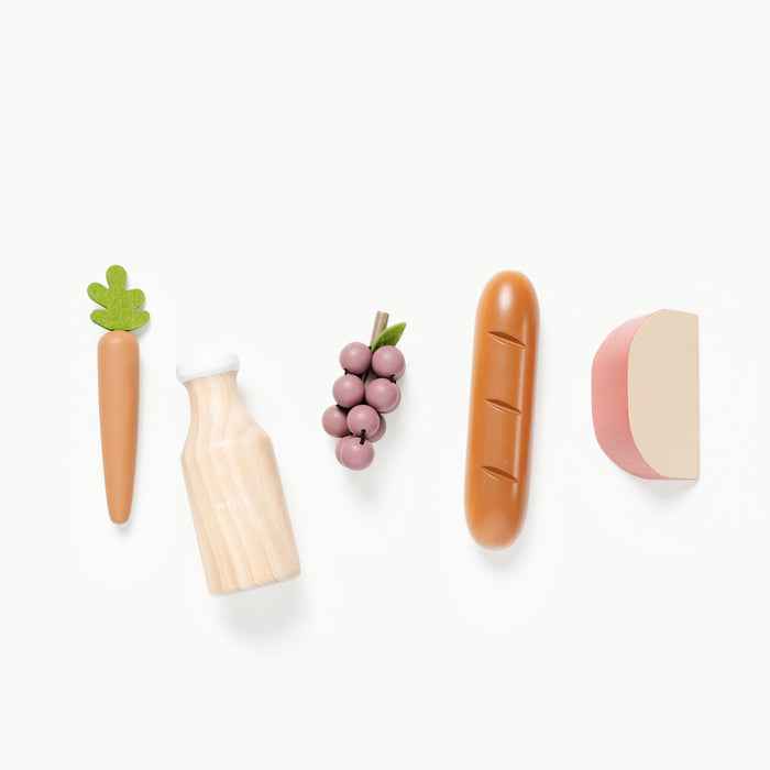wooden grocery toys laid out in a line, carrot, milk, grapes, bread, cheese