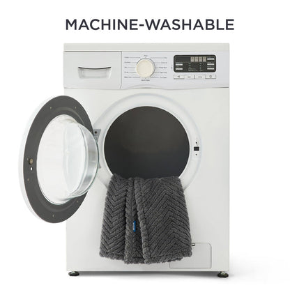 Dark grey chevron jacquard fleece pet blanket draped over an open washing machine door, highlighting easy-care feature.