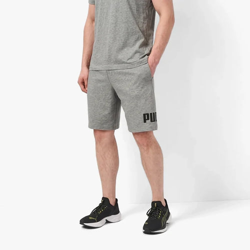 Grey Puma men's Ess Big Logo No 1 10-inch shorts with a prominent black Puma logo on the left leg, worn by a model.