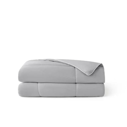 Soft grey nylon cooling comforter, folded, with white piping and breathable texture.