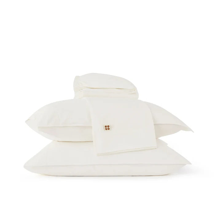White organic cotton sheet set with a brand logo on a white background