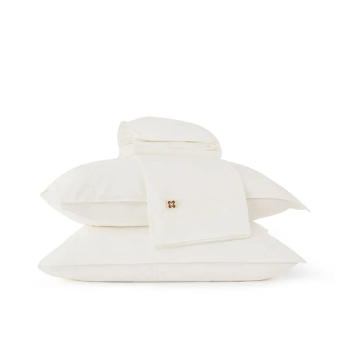 White organic cotton sheet set with a brand logo on a white background