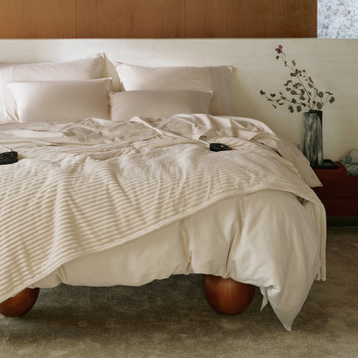 Organic cotton smart warmth bundle: bed with ribbed heated blanket, duvet cover, and sheets.