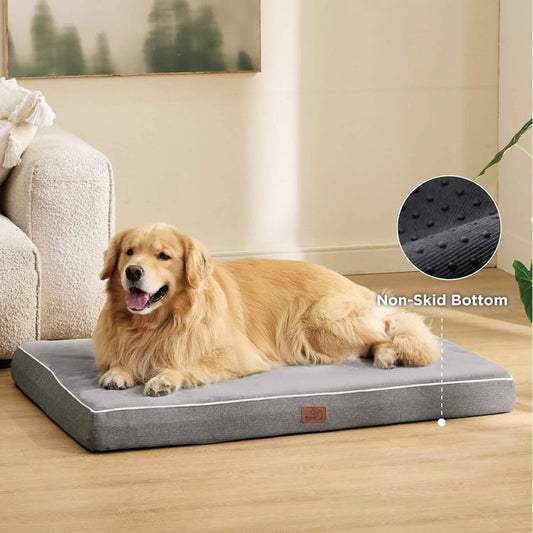Golden retriever relaxing on a gray orthopedic memory foam dog bed with non-skid bottom detail.