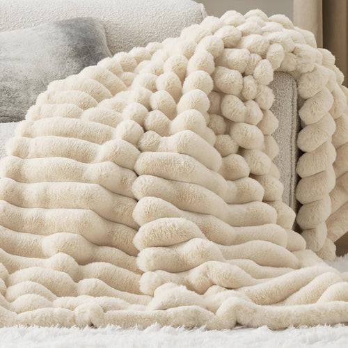 GentleSoft Plush Stripe Blanket in cream, draped over a sofa, showcasing its soft faux fur texture and cozy design.