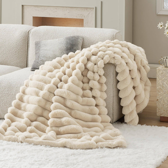 GentleSoft plush cream stripe faux fur blanket with ribbed texture draped on a sofa, showcasing cozy style.