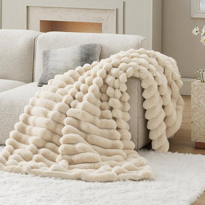 GentleSoft plush cream stripe faux fur blanket with ribbed texture draped on a sofa, showcasing cozy style.