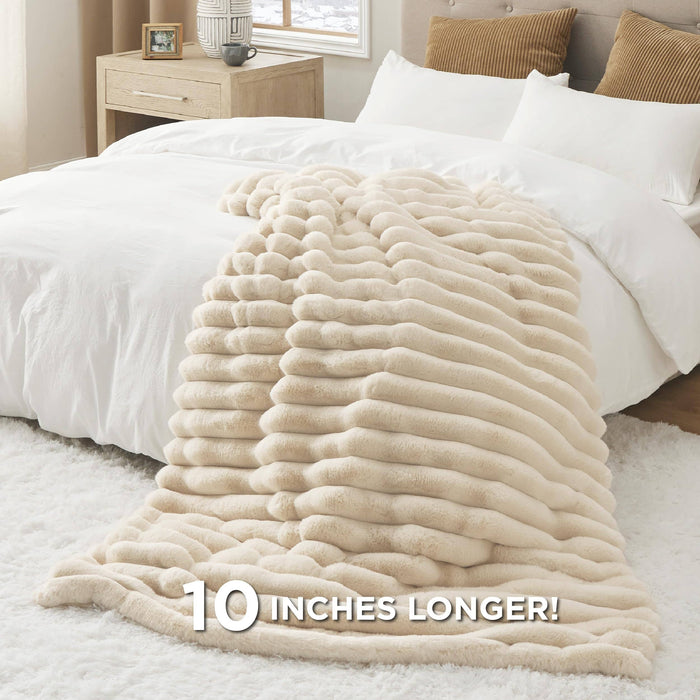 GentleSoft plush cream striped blanket 50"x70" on bed, text highlights "10 INCHES LONGER!".