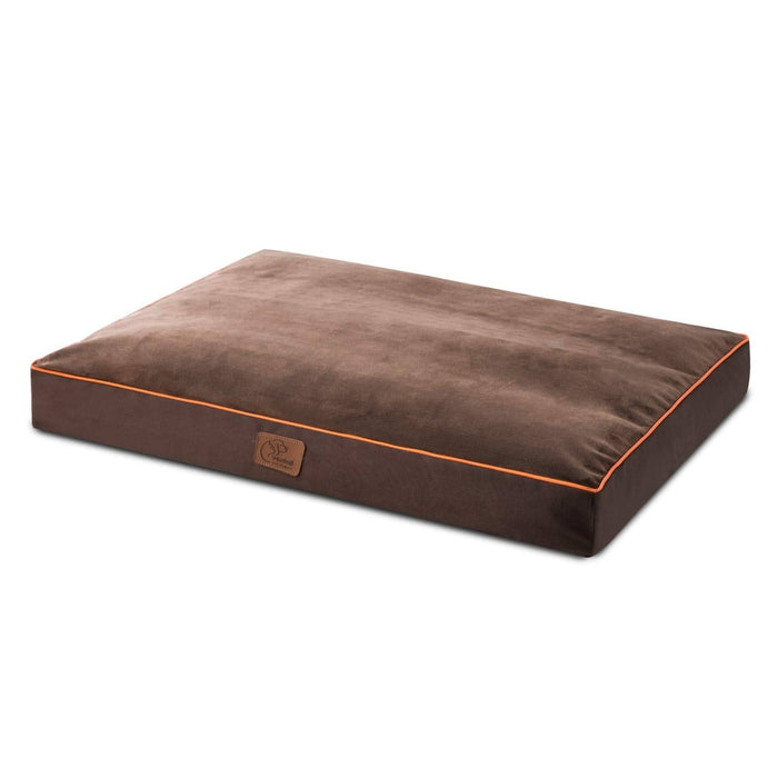 Plush brown waterproof dog bed with orange piping, featuring a soft velvety top and a small leatherette logo tag.