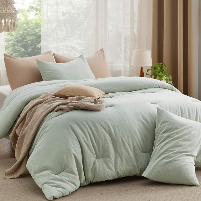Pale green GentleSoft prewashed cotton comforter set with wrinkled texture on a bed, styled with accent pillows and throw.