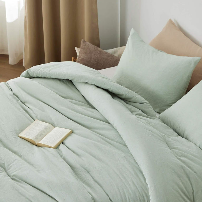 Pale green prewashed cotton comforter set with natural wrinkles on a bed, accented with pillows.