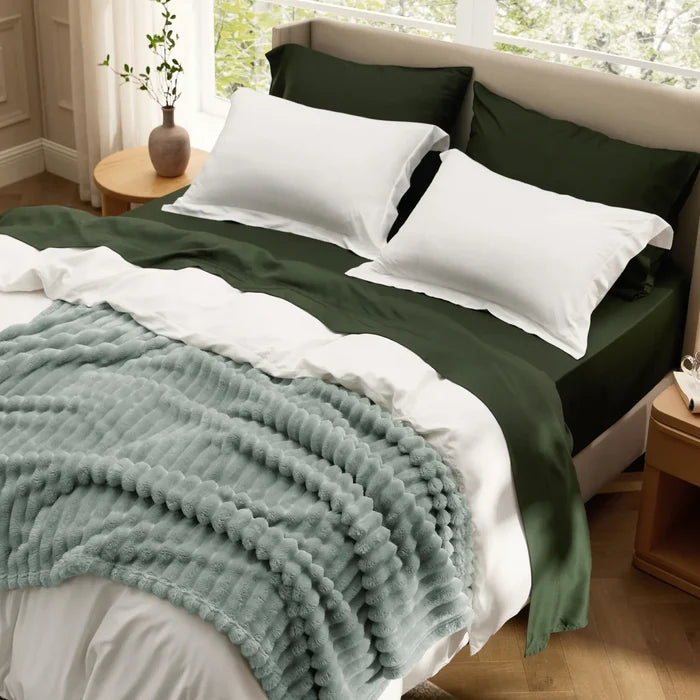 Rayon derived from bamboo cozy bedding bundle: green duvet, white sheets, textured blue blanket.