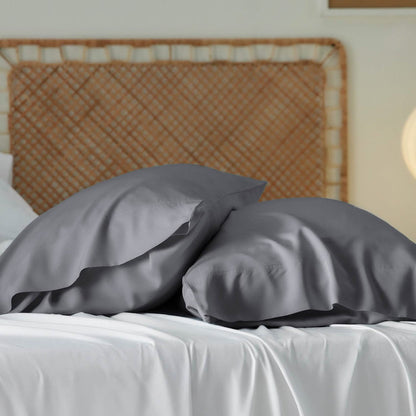 Two charcoal grey GentleSoft rayon derived from bamboo pillowcases with a smooth, lustrous sheen draped on white sheets.