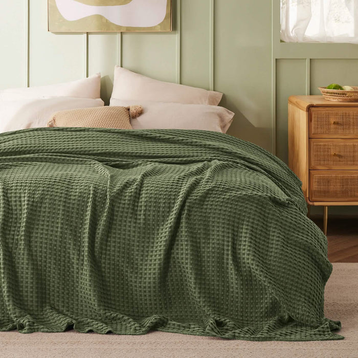 Olive green GentleSoft cooling waffle blanket on bed. Bamboo-cotton blend, waffle texture.