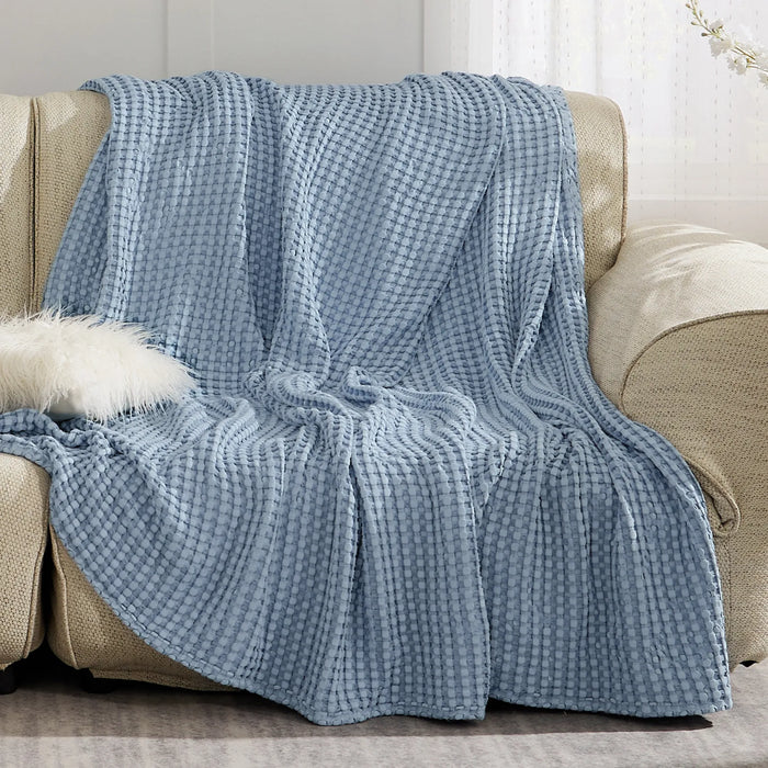 Soft blue waffle weave rayon derived from bamboo blanket on sofa.