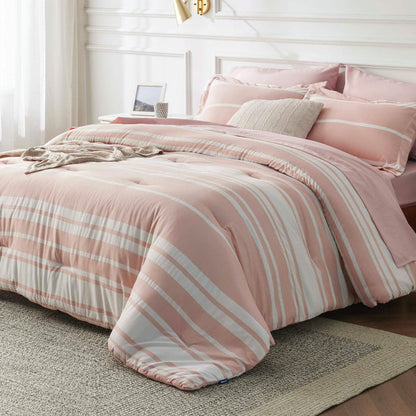 GentleSoft pink and white striped reversible bed-in-a-bag comforter set shown on a made bed.
