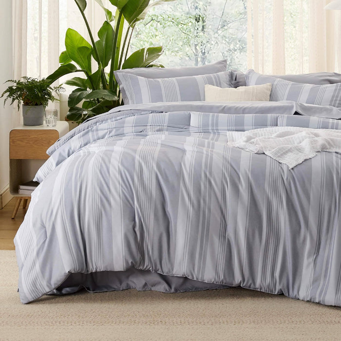 GentleSoft reversible king comforter set with light grey and white vertical stripes on a made bed.