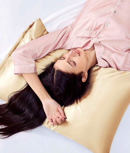 Woman sleeping on a soft gold satin body pillowcase, reducing hair friction and promoting skin health.
