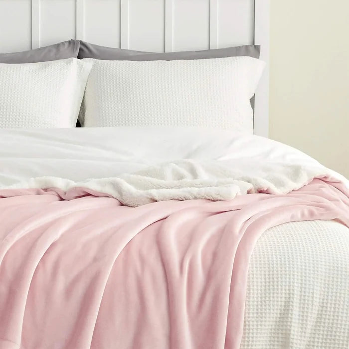 Pink GentleSoft Sherpa Fleece Blanket draped on bed, showcasing dual-sided plush and velvety textures.