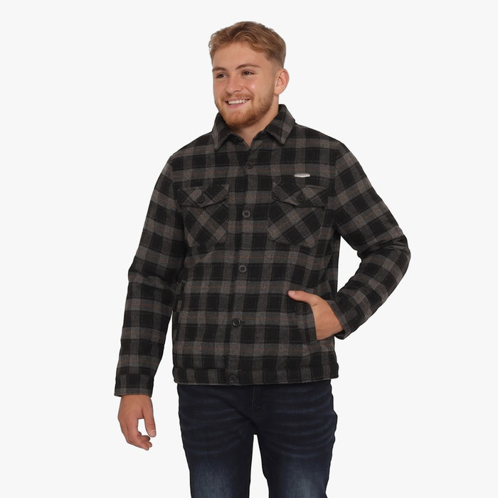Young man modeling a Soviet Mens Boden Check Jacket in black and grey plaid, paired with dark blue jeans, standing against a