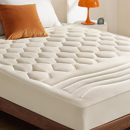 Off-white three-zone quilted mattress pad featuring honeycomb and wave patterns.