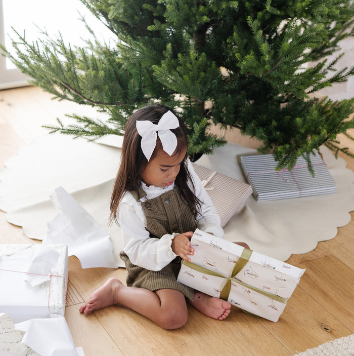 Ivory Scallop (on sale)@Kid opening gift near tree with Ivory Scallop Tree Skirt under it