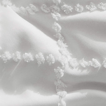 Close-up of white GentleSoft comforter showing diamond tufted embroidery and soft polyester texture on product page.