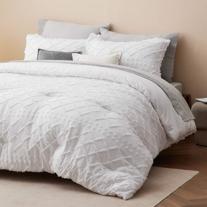 GentleSoft white comforter set with textured diamond tufting on a styled bed for bedroom decor.