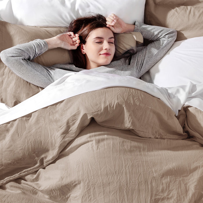 Woman stretching in taupe GentleSoft microfiber duvet cover set, emphasizing soft comfort and bedroom aesthetic.